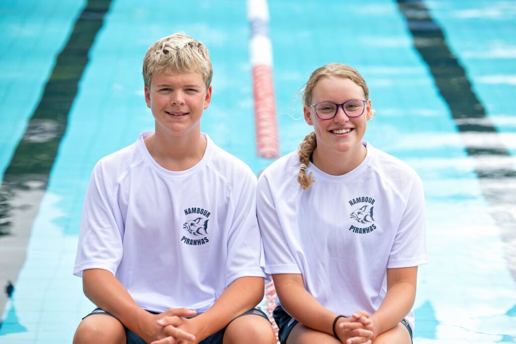 Adam and Imogen sitting in front of the Nambour Aquatic Centre pool